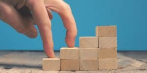 Getting career growth concept, Fingures walking on stacked wooden blocks stairs