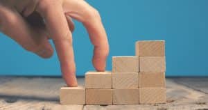 Getting career growth concept, Fingures walking on stacked wooden blocks stairs