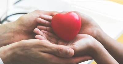 Doctor hands holding and giving red massage heart to patient
